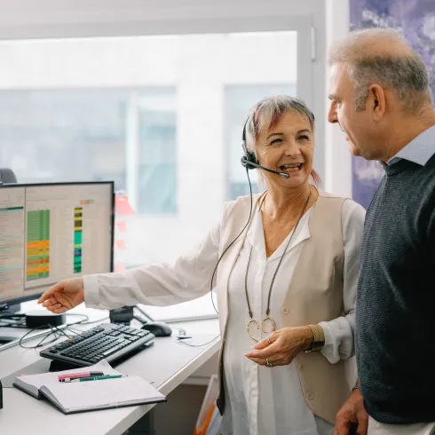 Zwei Personen sprechen vor PC