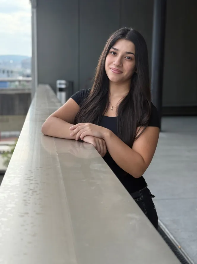 Junge Frau mit braunen Haaren, lächelnd und stehend
