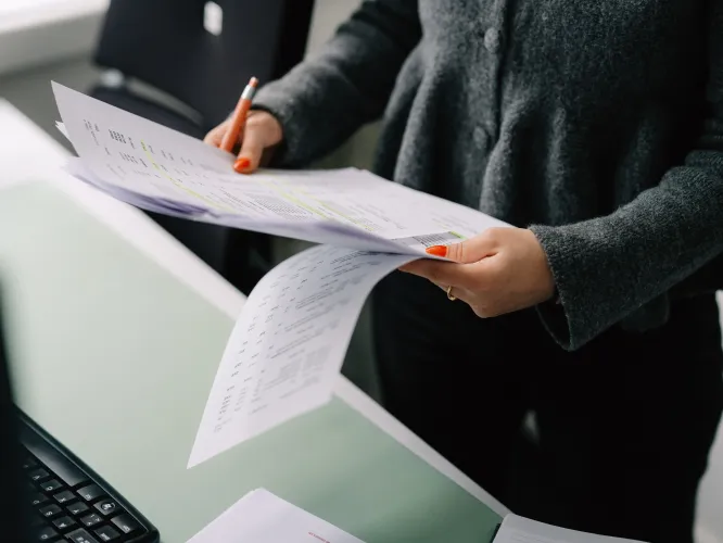 Hand von einer Frau, welche ein Papier hält