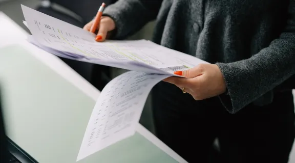 Hand von einer Frau, welche ein Papier hält